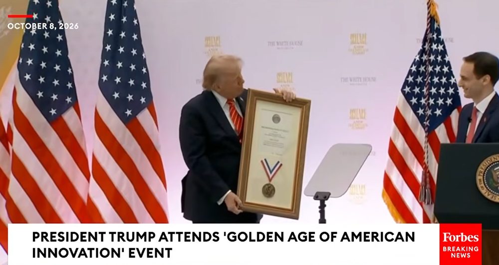 President Trump holds his uncle John G. Trump's framed National Medal of Science